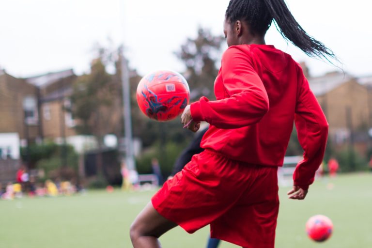 Young female football player training outside.