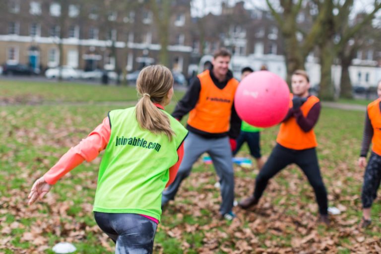 Group of young people playing outdoor sport with fitness ball