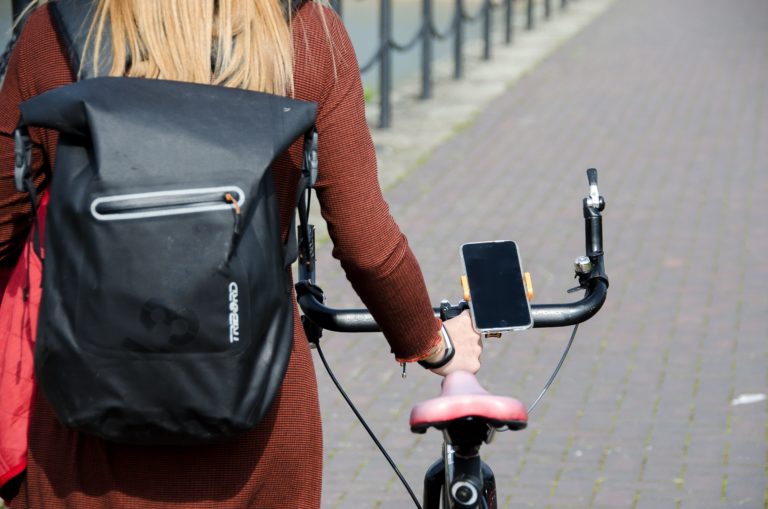 Female cyclist pushing bike using sport tech