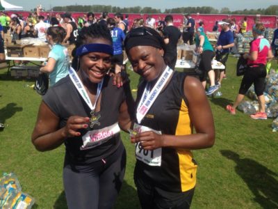 Two females members of S Factor Academy posing with their medals for completing Run Hackney
