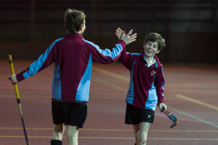 Two young boys high-fiving during a hockey match
