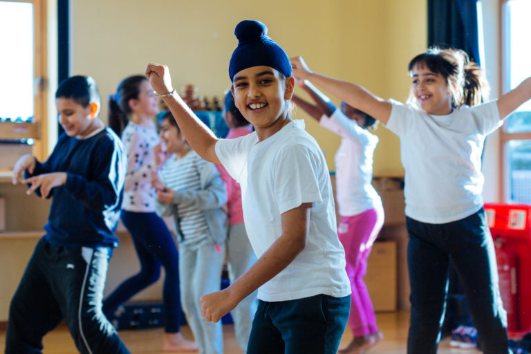 Group of children smiling while dancing