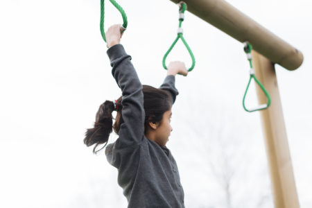 Children at school hanging from monkey bars