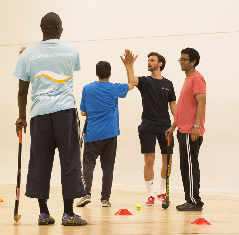 Volunteer clapping hands with participant at Disability Sports Coach's Summer Festival 2017