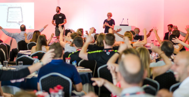 A large group of people doing chair exercise at a London Sport conference